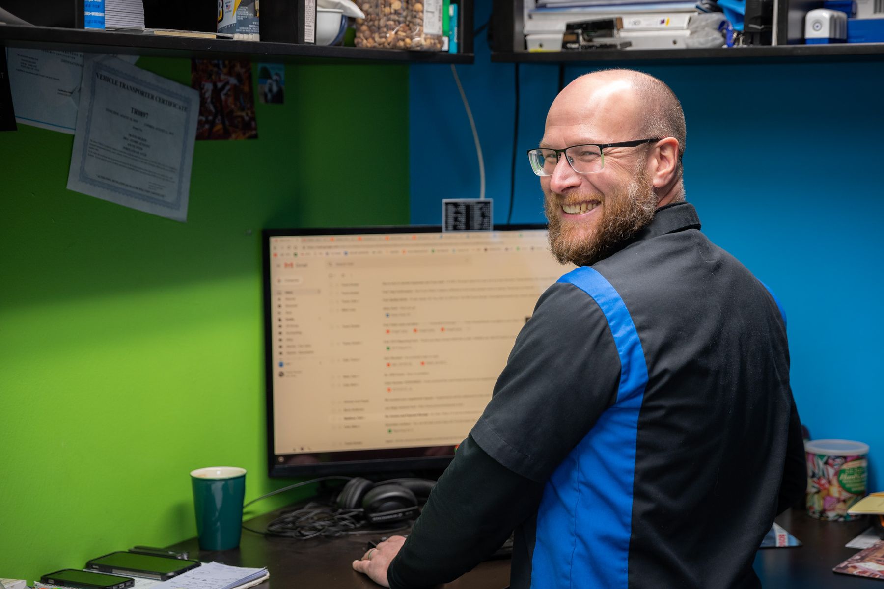 One of the Atomic crew smiling over his shoulder at the front desk computer