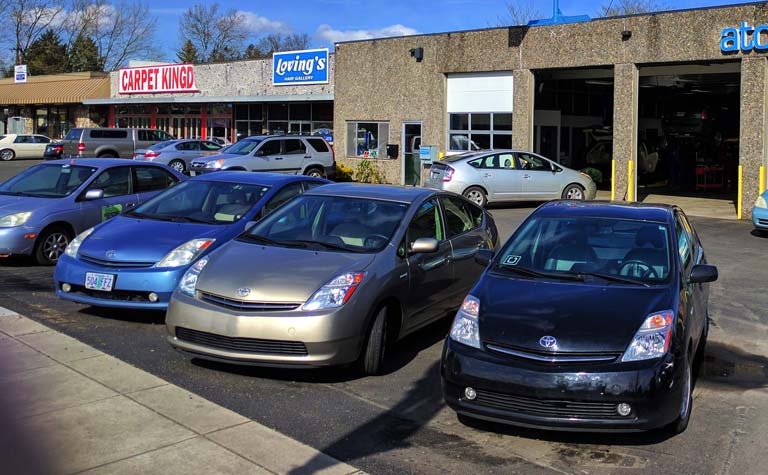 Four Atomic Auto loaner Priuses parked outside the bays