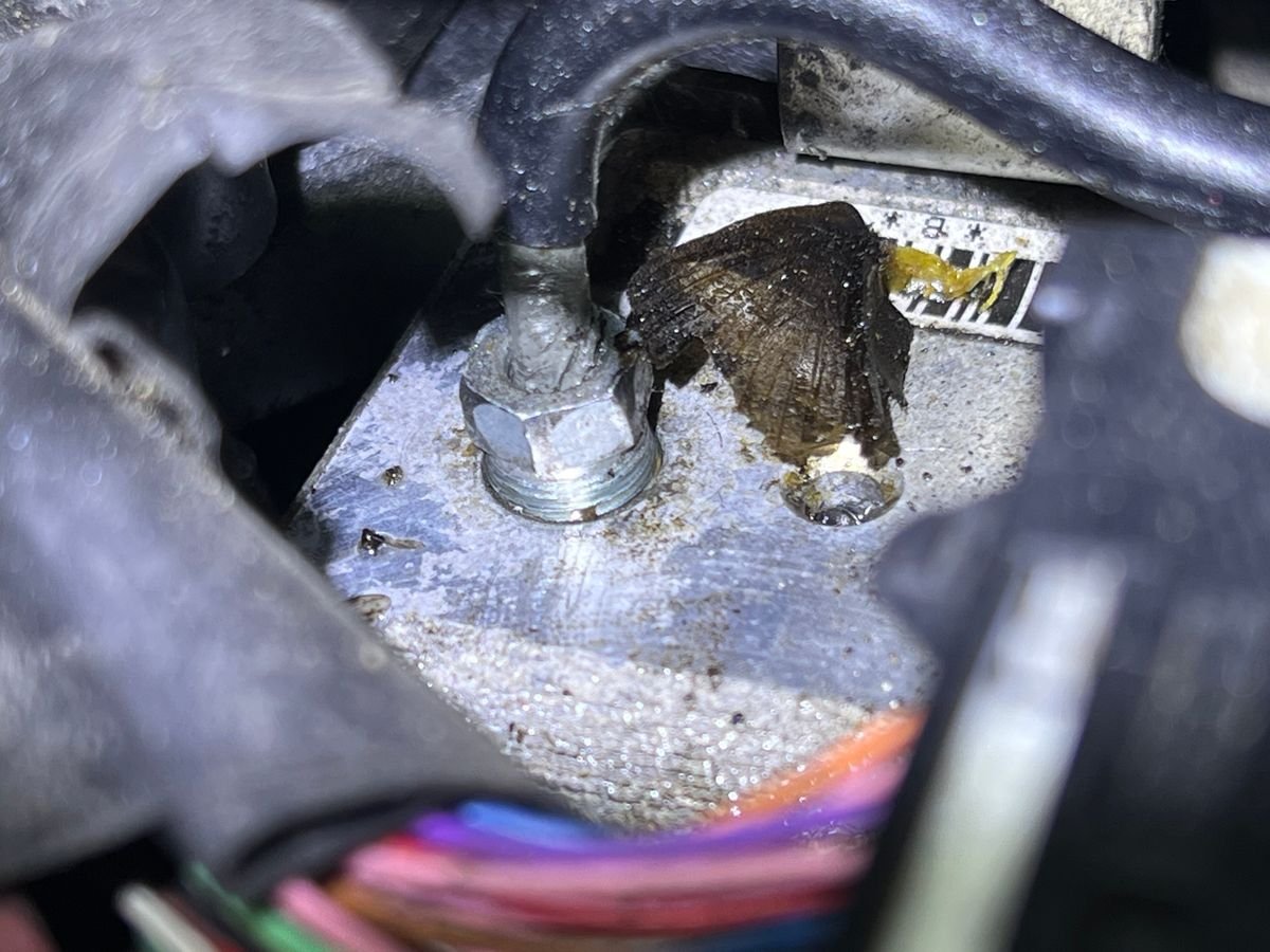 Top of a 2009 Prius brake actuator with wet, grimy brake fluid around the line fitting that was leaking